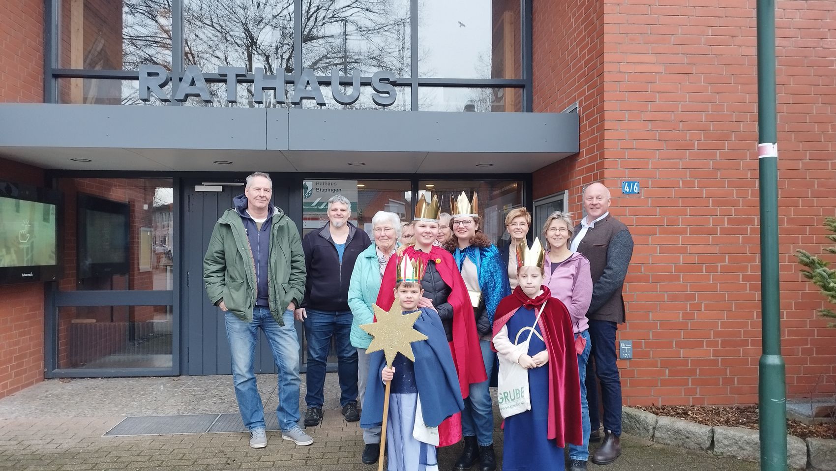 Das Foto zeigt die Sternsinger gemeinsam mit Bürgermeister Dr. Jens Bülthuis, den Mitarbeitern und Mitarbeiterinnen der Verwaltung vor dem Rathaus der Gemeinde Bispingen.