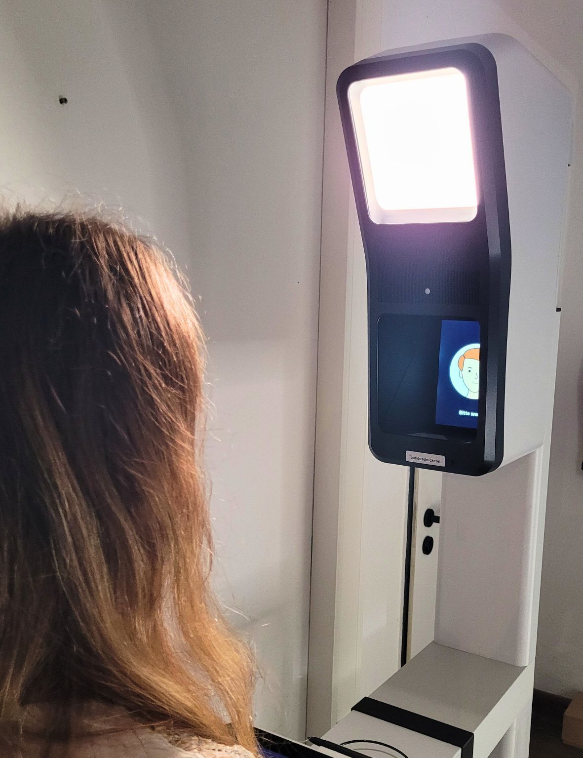 Eine Frau steht vor dem Bildautomaten
