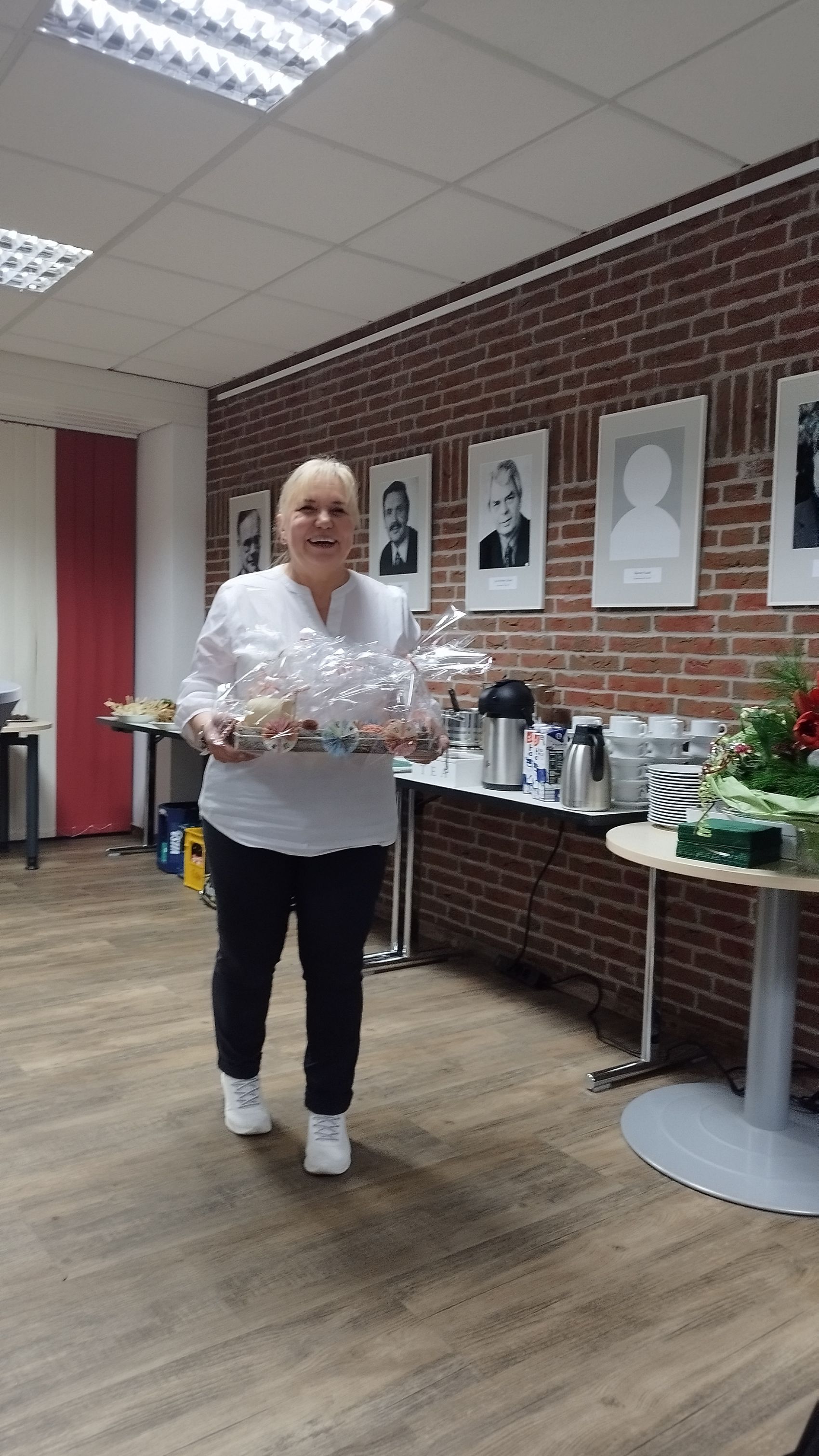 Das Bild zeigt Regina Staubesand mit einem Geschenk in der Hand.