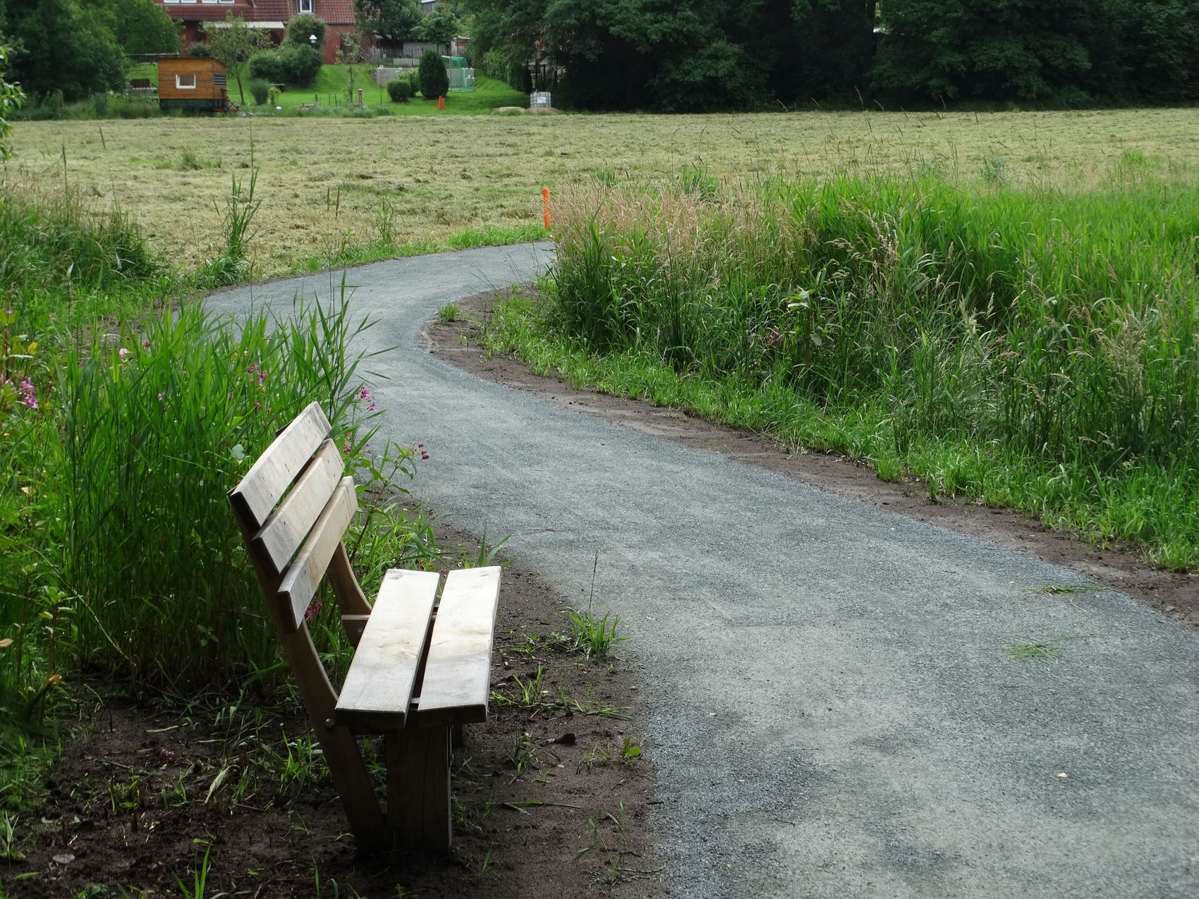 Die Sitzbank lädt zum Verweilen ein. Das Bild zeigt eine Sitzbank, die entlang des Wanderweges entlang der Luhe steht.