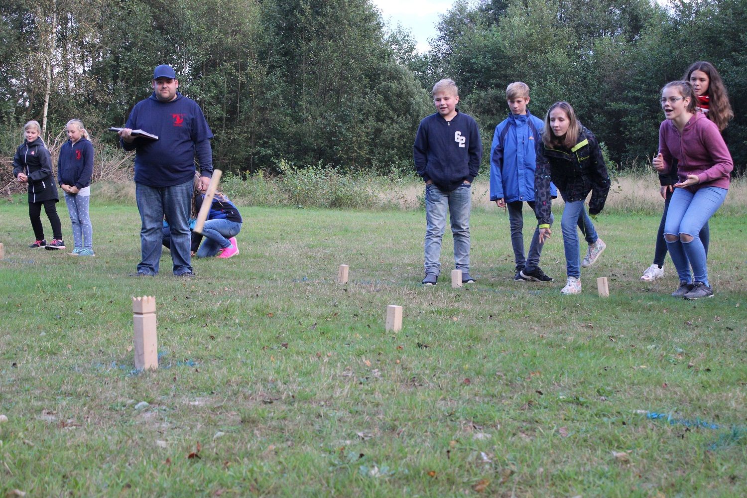 Jugendfeuerwehrmitglieder spielen Wikinger-Schach auf einer Wiese
