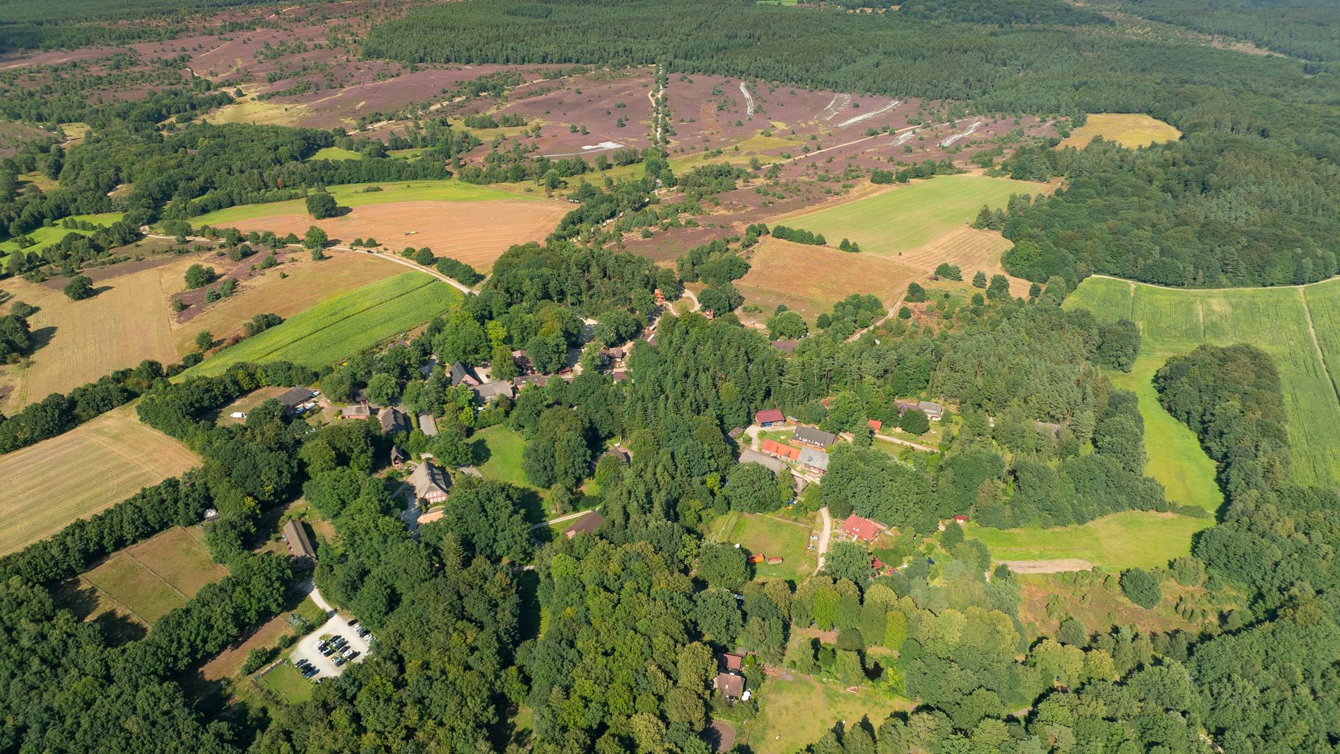 Luftbildaufnahme von Oberhaverbeck 2024, zeigt eine weitläufige Landschaft mit Wäldern, Feldern und verstreuten Wohngebieten.